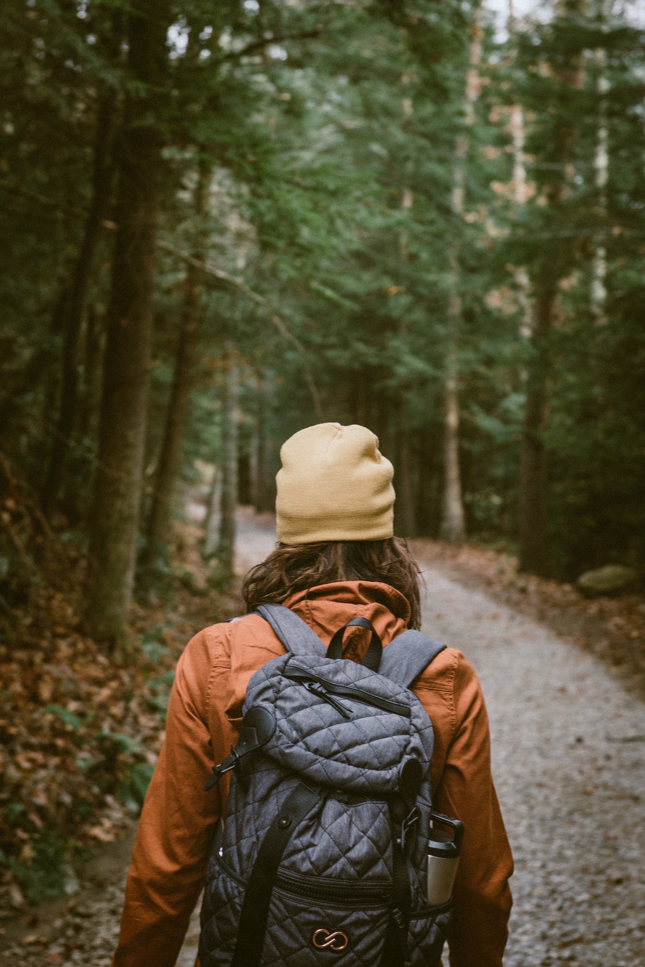 Woman rucking through a forest trail with a loaded backpack